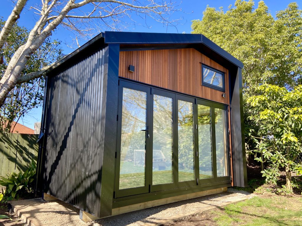 Fox Den Mezzanine Cabin by Fox Cabins, Raglan. Front wall in Hermpac Cedar with 4 Meter wide bifold doors.