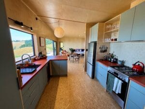 The Kitchen of The Bach Two Bedroom Modular Home by Fox Cabins showing custom cabinets and concrete countertop